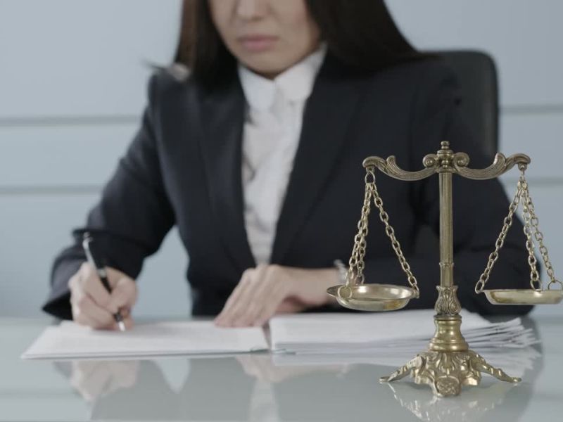 advokatica u kancelariji popunjava dokumente