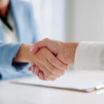 osobe se rukuju nakon potpisivanja ugovora