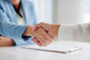 osobe se rukuju nakon potpisivanja ugovora