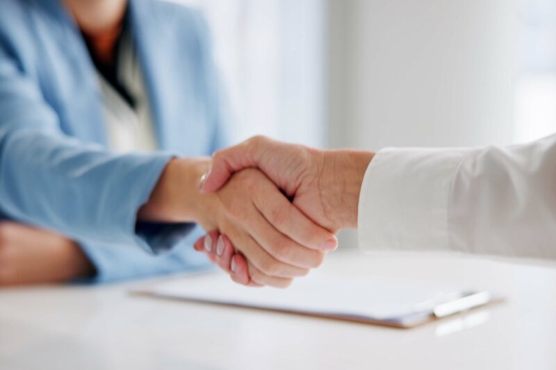 osobe se rukuju nakon potpisivanja ugovora